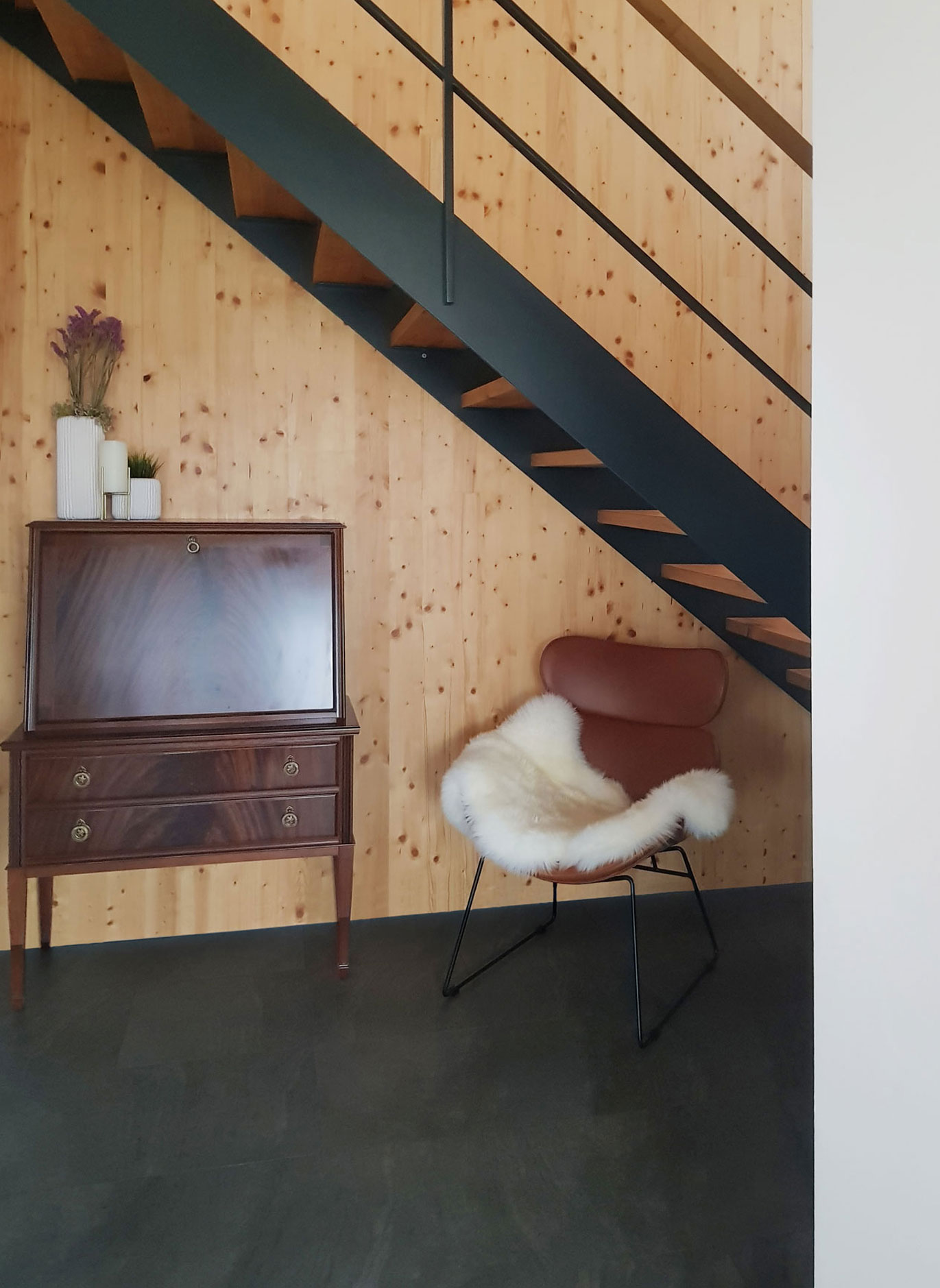 Treppe mit schwarzer Stahlkonstruktion und Holzstufen in Haus PF