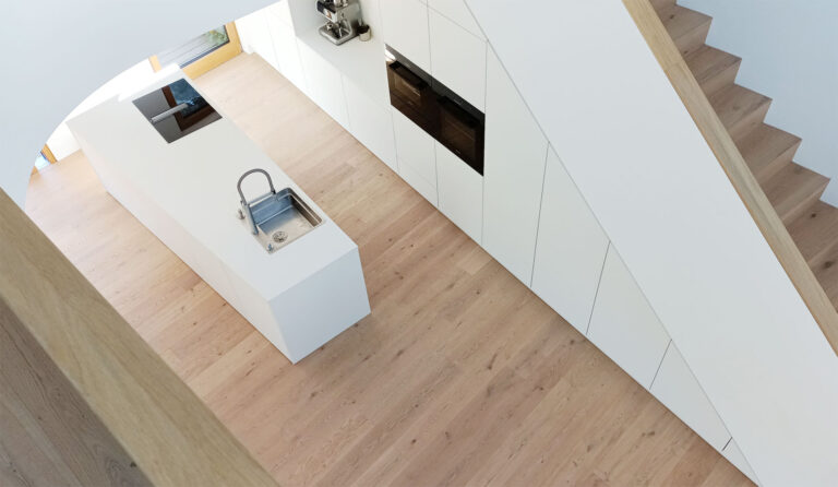 Blick von der Galerie auf eine minimalistisch gestaltete Küche mit weißer Kochinsel und Einbaumöbeln.