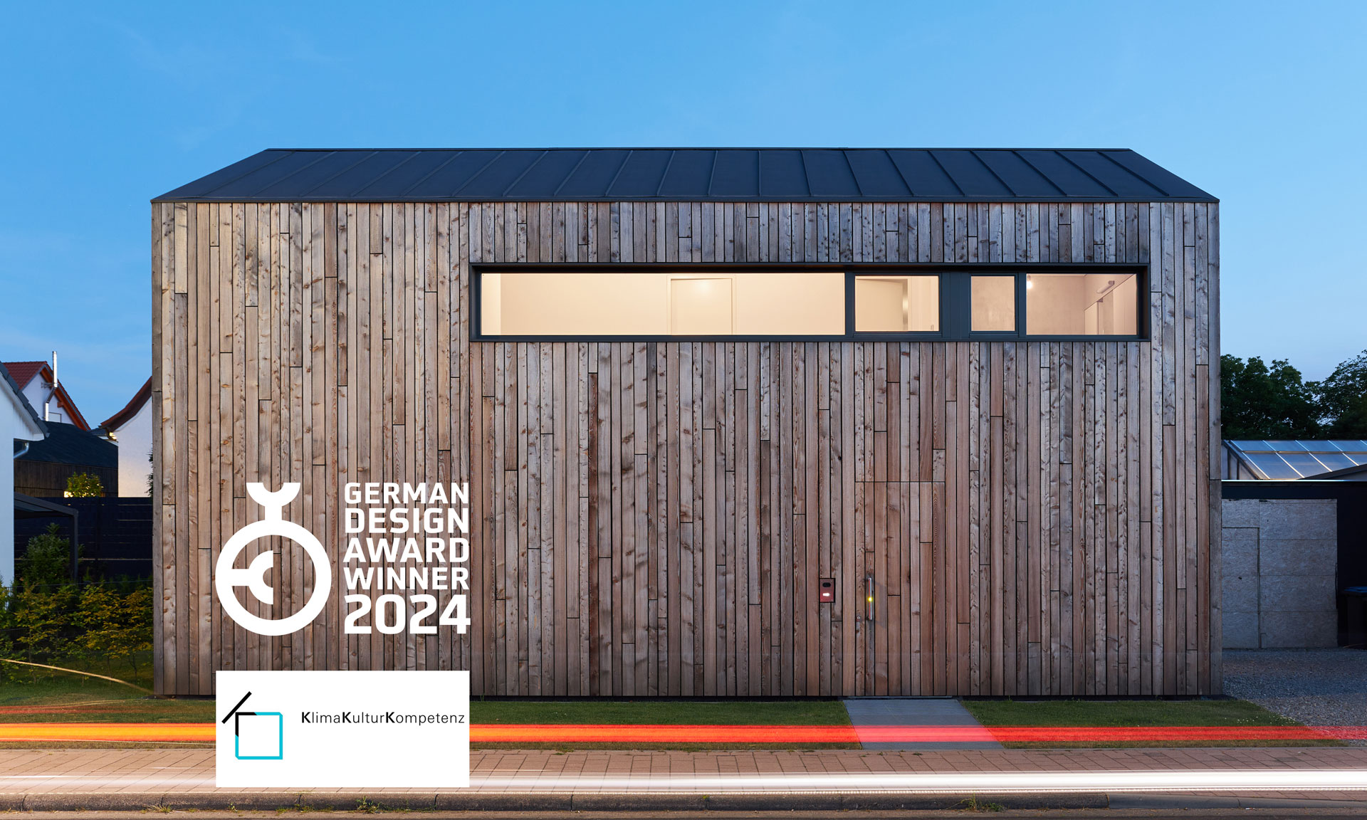 Haus VV mit vertikaler Holzfassade und Auszeichnungen „German Design Award Winner 2024“ und "Klima Kultur Kompetenz"
