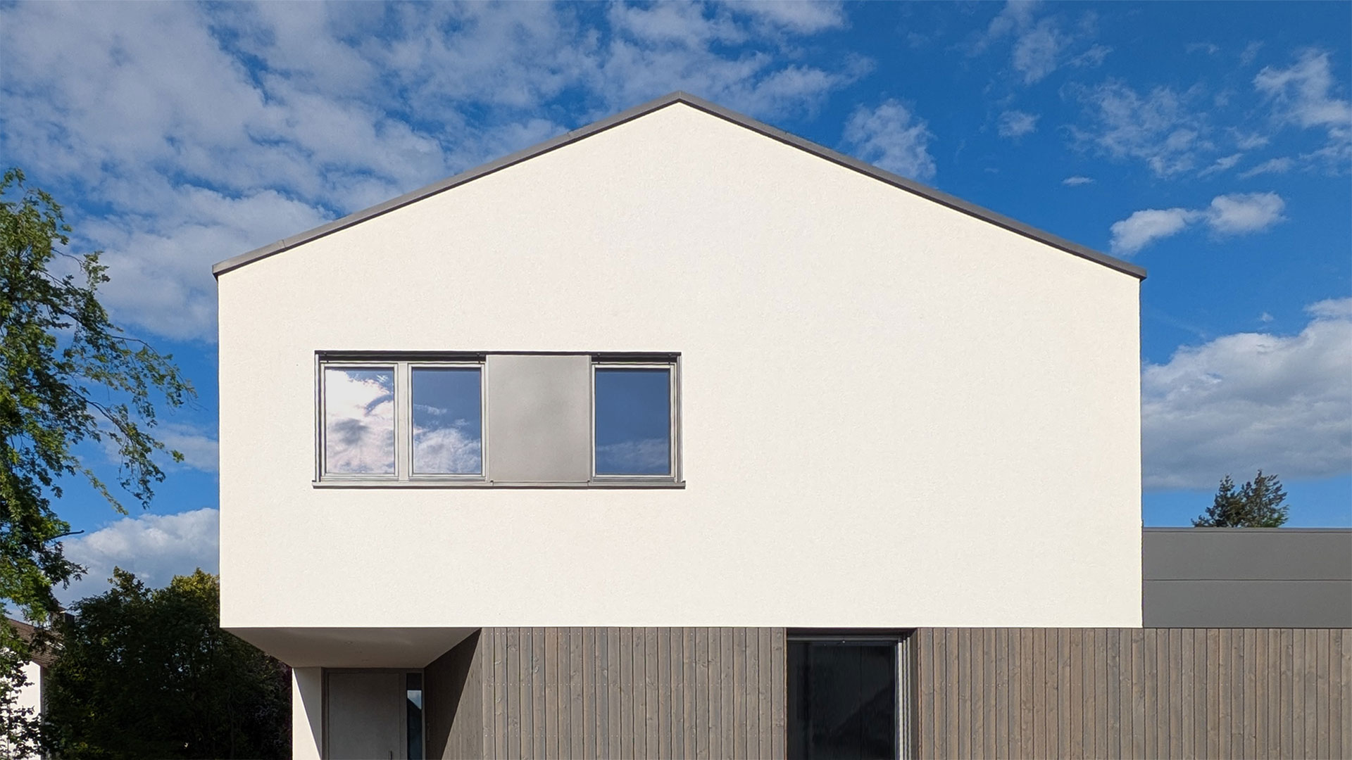 Straßenansicht eines modernen Einfamilienhauses mit weißer Putzfassade